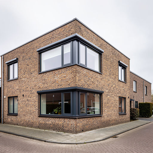 gerenoveerde hoekwoning in Hooge Zwaluwe met donkergrijze kunststof kozijnen op jaren-70 gevel
